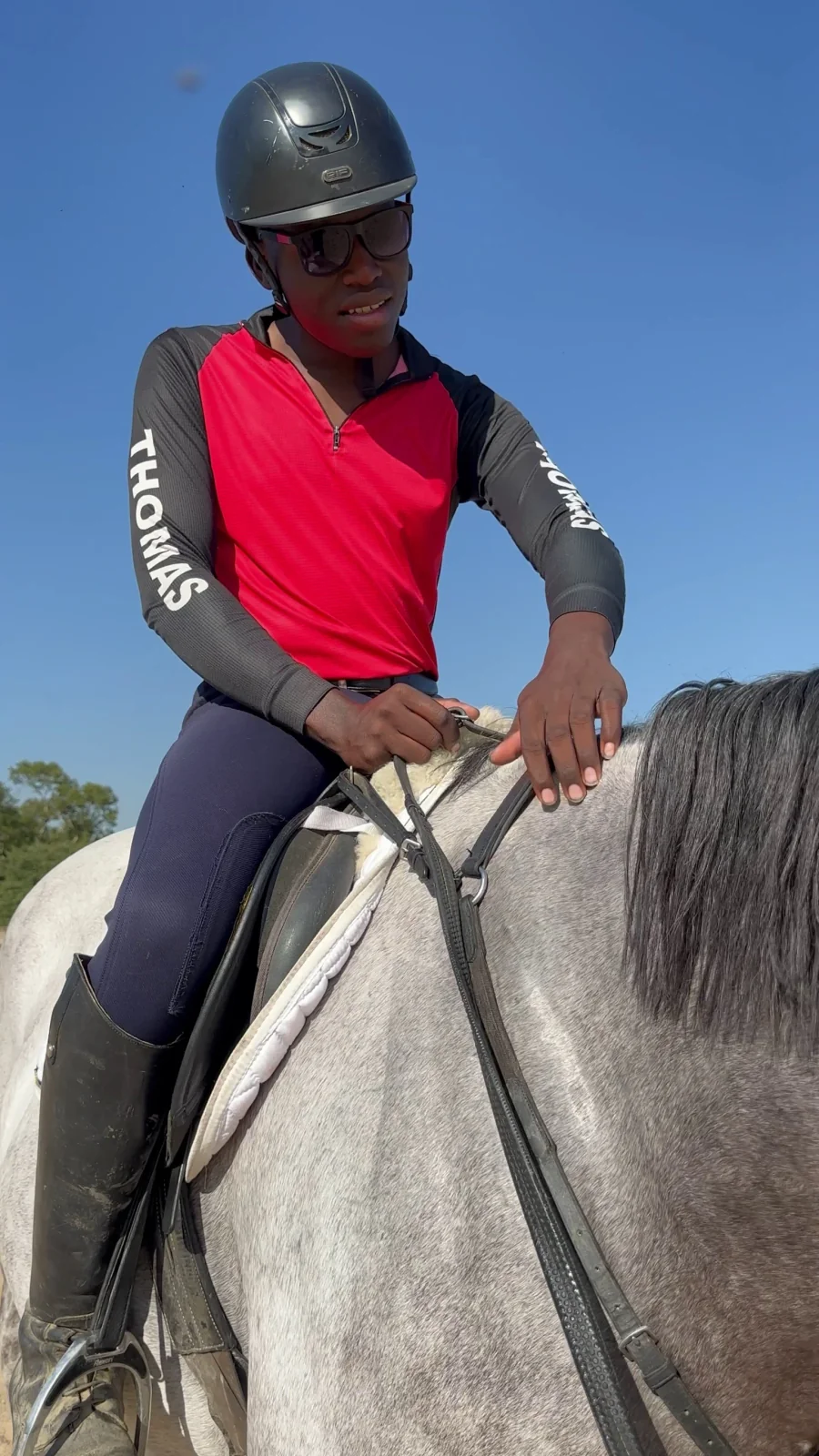 Rider in a red vest mounted on a grey horse at Bilavadu